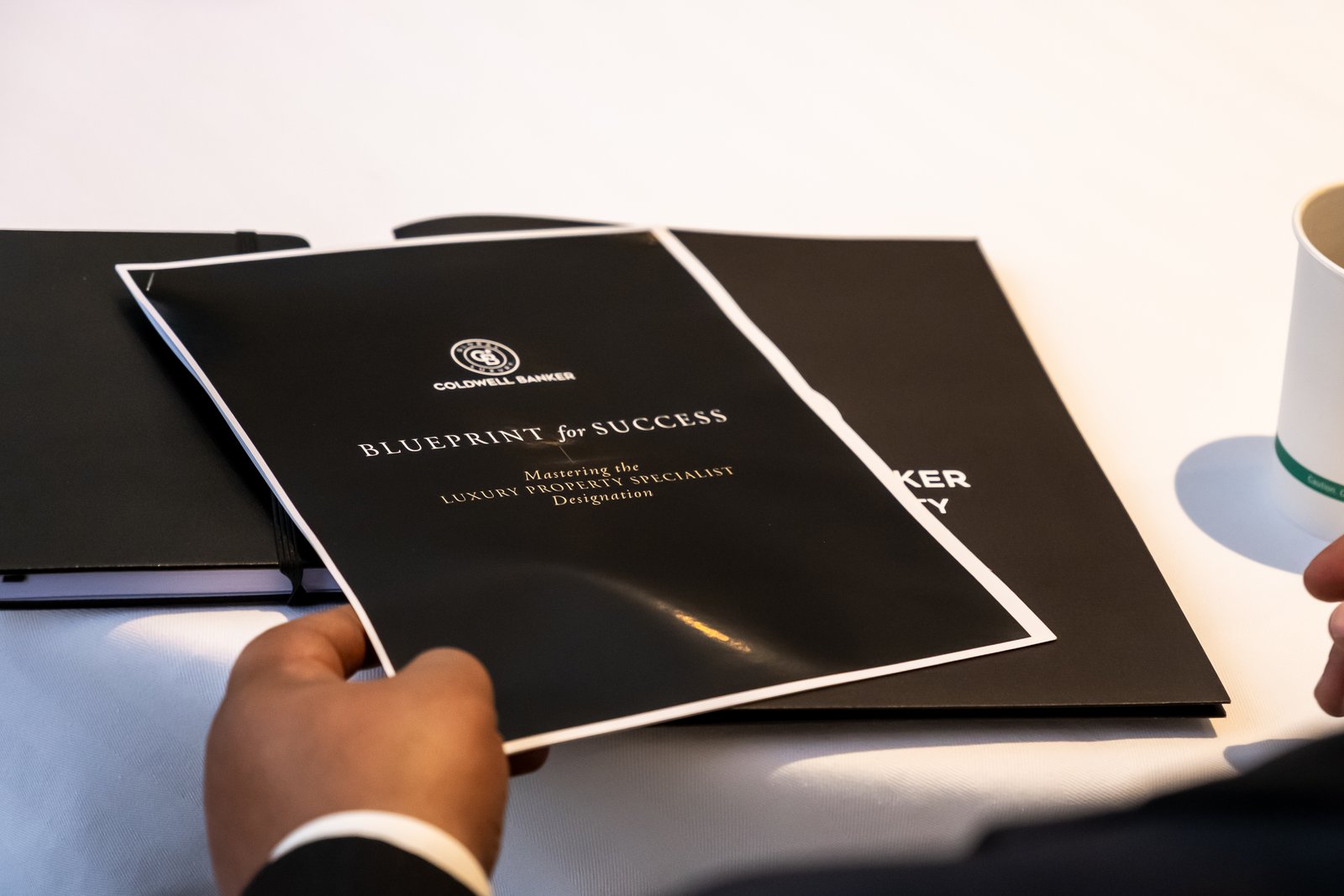 Printed event materials held at a table