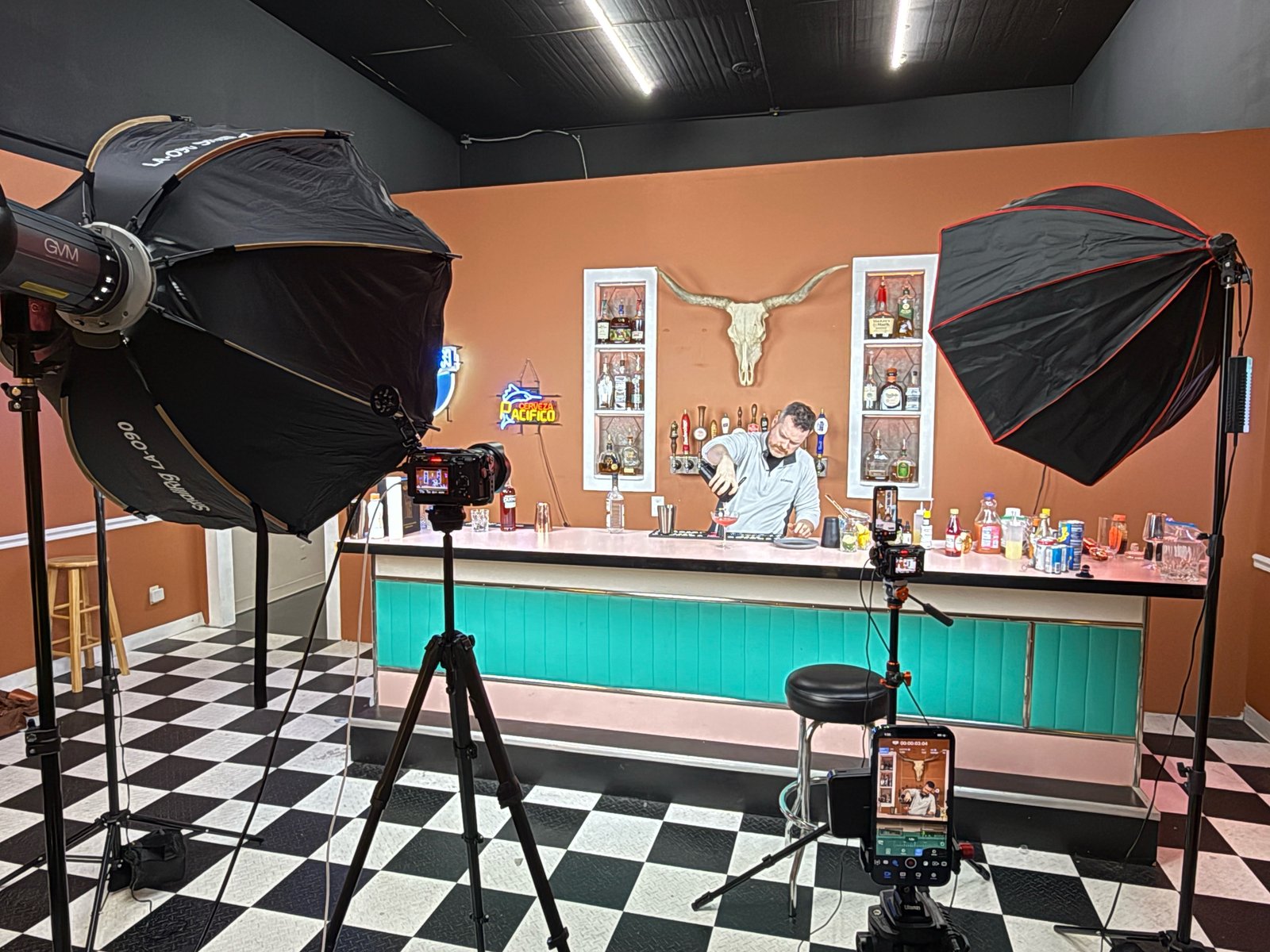 A brand shoot in progress with two softboxes and two cameras set up around a bar