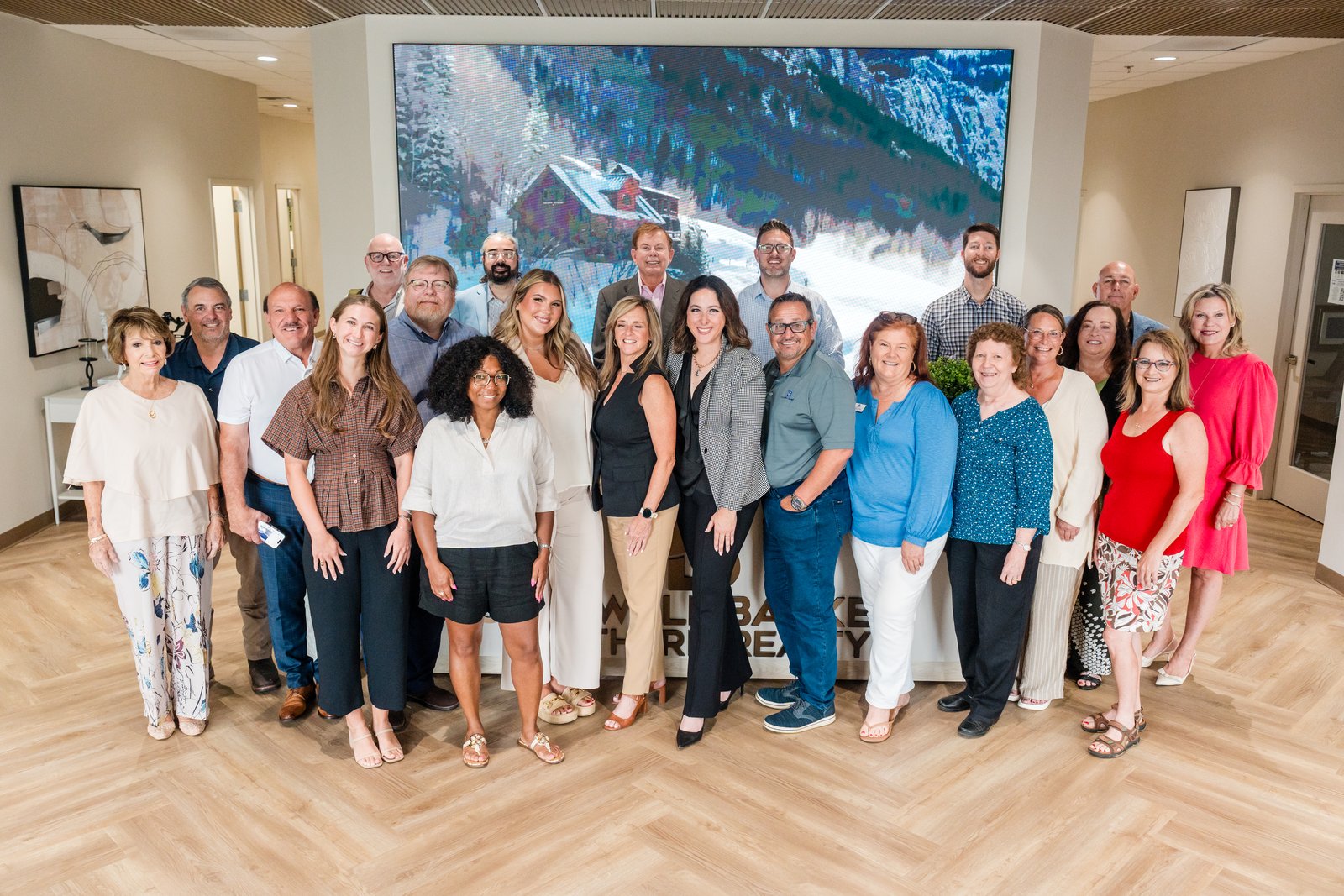A large team gathered for a group photo at a brokerage office