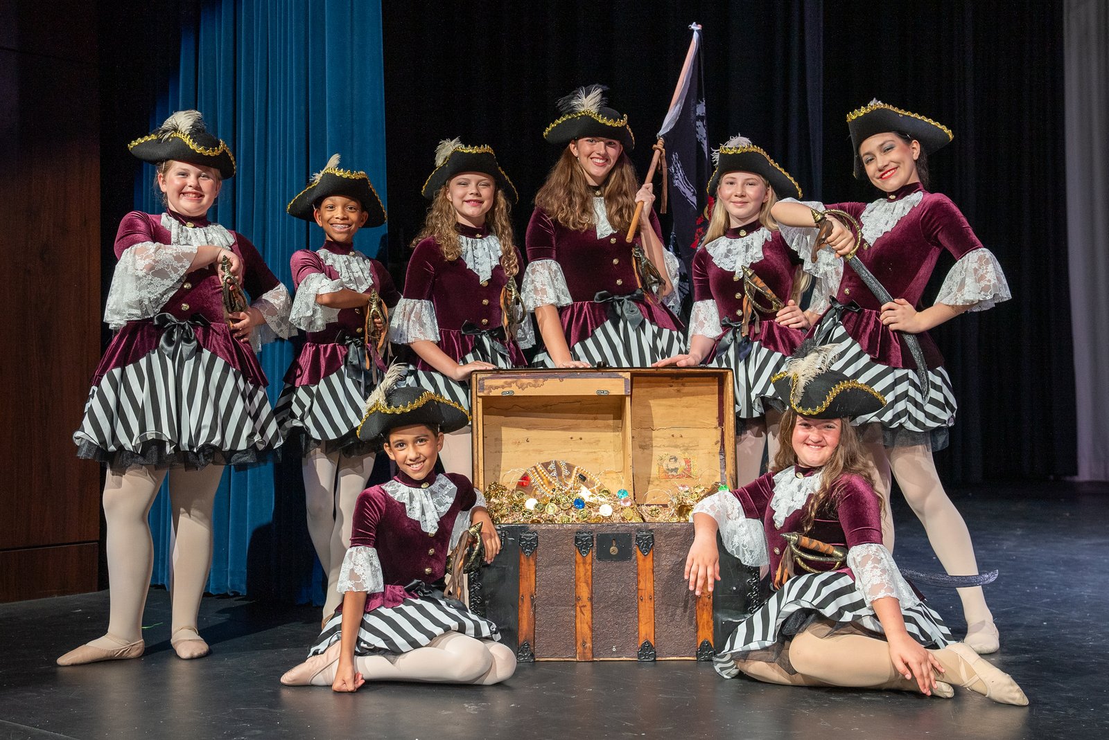 A character ballet number in pirate costumes gathered around a treasure chest on stage