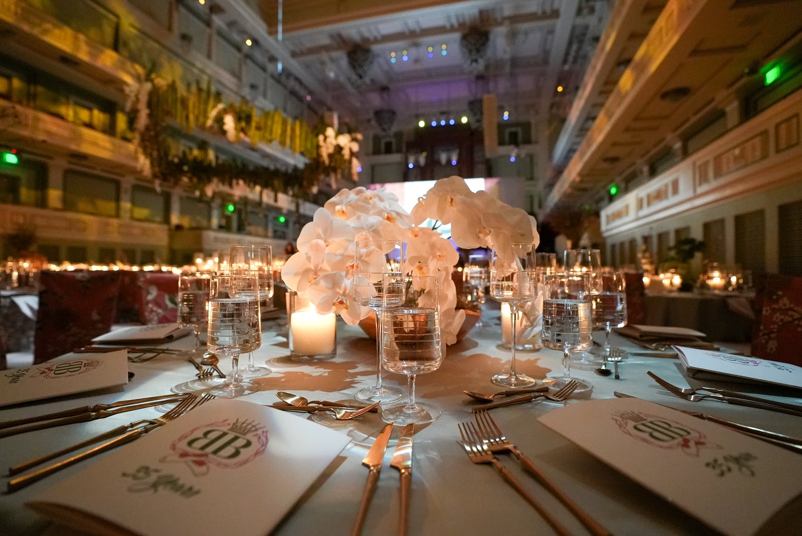 A place setting with orchids, candlelight and a printed menu