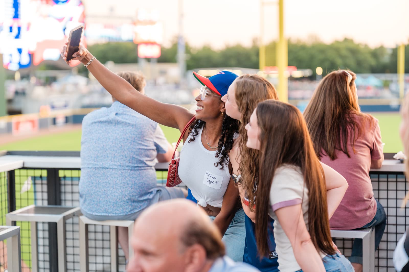 Three guests taking a selfie above the outfield at a company night out